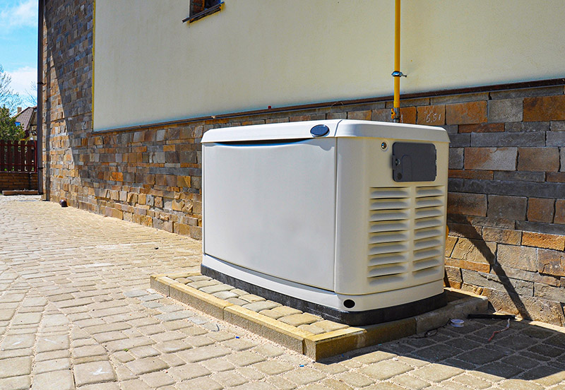 a standby generator located on the patio behind a house