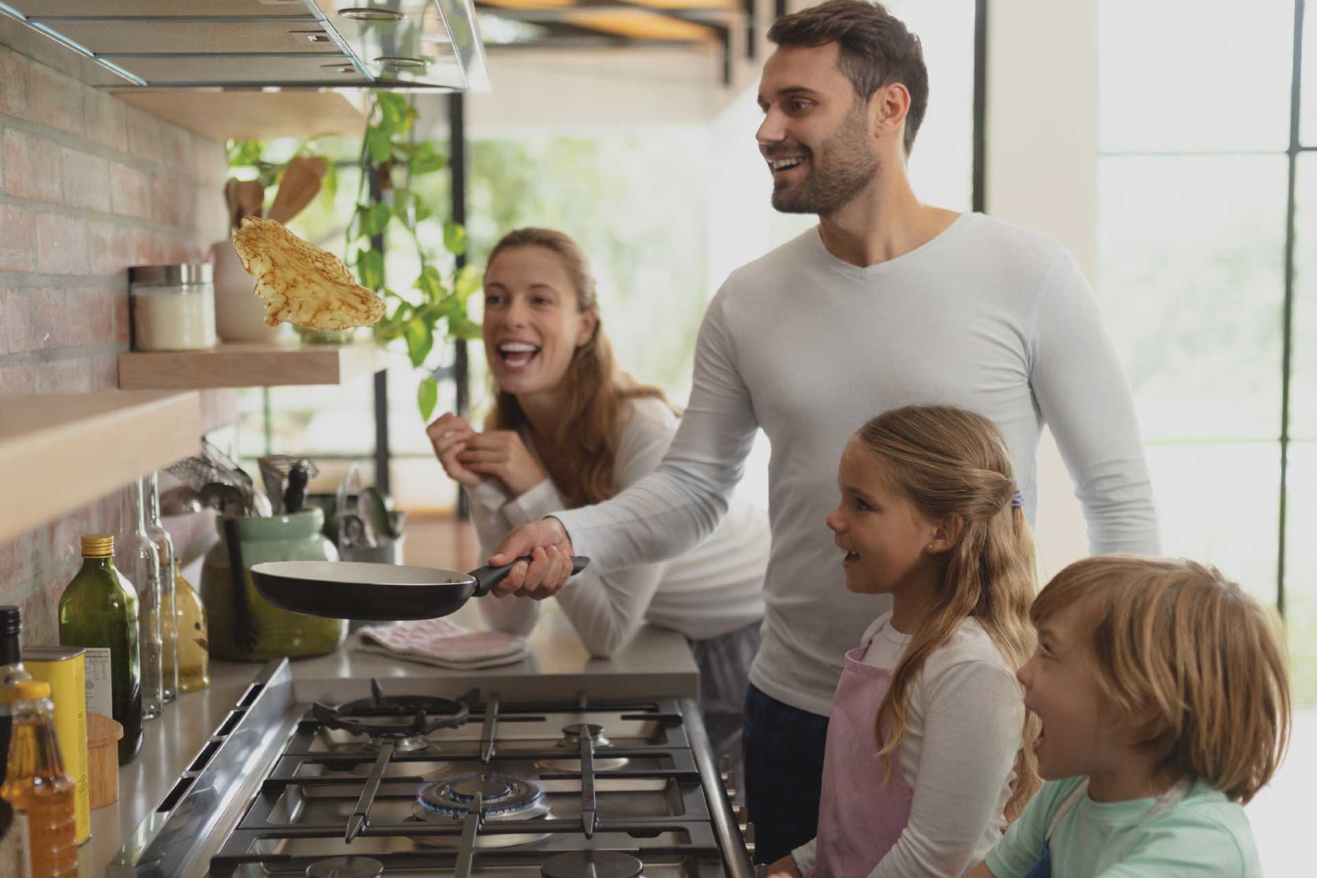 a family cooking a meal at a gas range.